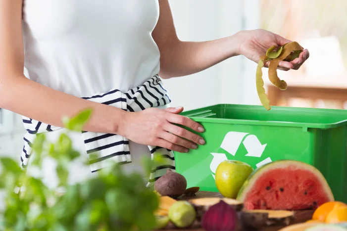 Person wirft Obstreste in Biotonne